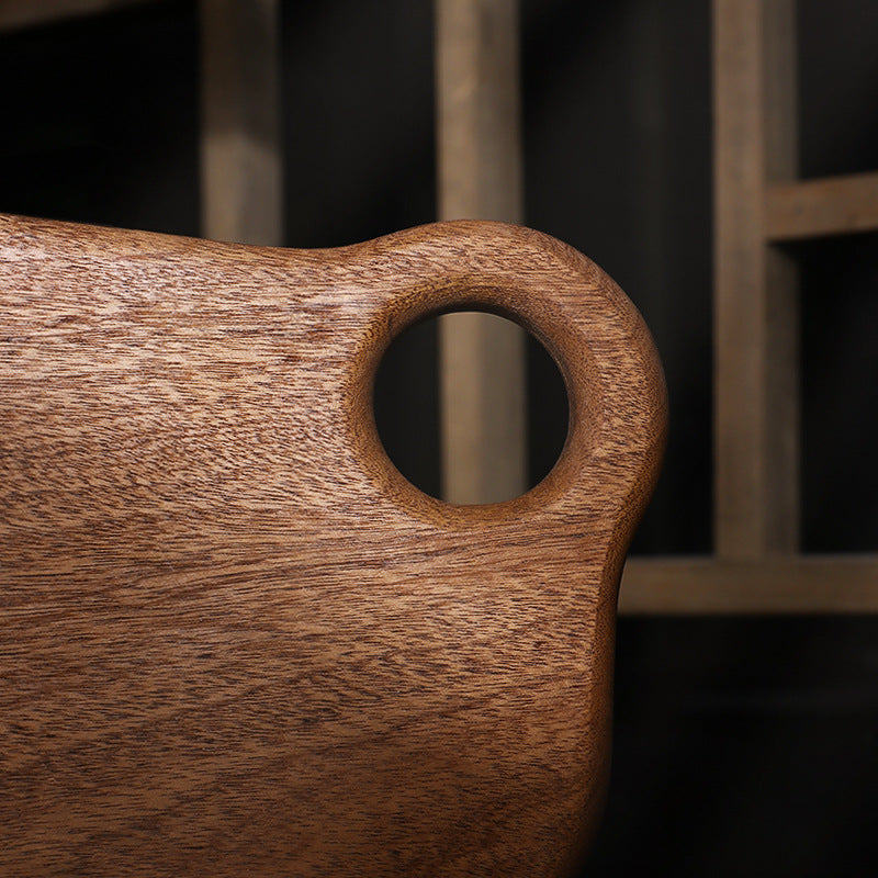 Close-up of a wooden cutting board with a handle.